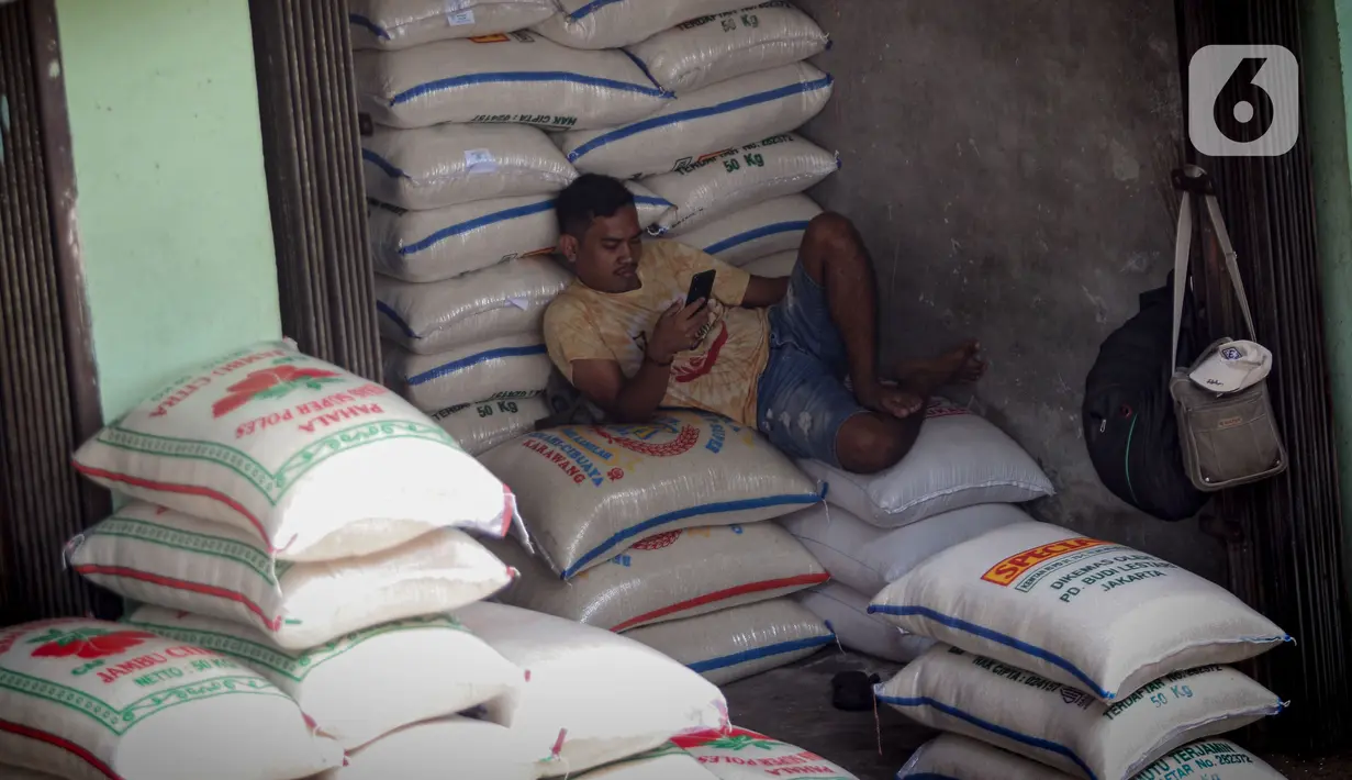 Pedagang bersantai di atas karung beras sambil menunggu pembeli di Pasar Kebayoran Lama, Jakarta, Selasa (26/9/2023). (Liputan6.com/Angga Yuniar)