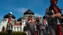 Turis asing mengenakan jilbab saat mengunjungi Masjid Agung Baiturrahman di Banda Aceh, Aceh pada 6 Agustus 2019. Selain sebagai tempat ibadah, Masjid Baiturahman juga menjadi tempat wisata bagi turis lokal dan mancanegara. (CHAIDEER MAHYUDDIN / AFP)