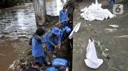 Pekerja Sudin Sumber Daya Air Jakpus menyelesaikan penutupan lubang rembesan di Tanggul Kanal Banjir Barat, Latuharhari, Minggu (5/1/2020). Penutupan untuk mengantisipasi tanggul jebol setelah diketahui terdapat rembesan di sejumlah titik akibat debit air KBB meningkat. (merdeka.com/Iqbal Nugroho)