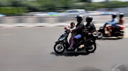 Seorang pengendara sepeda motor saat melintas di kawasan Bundaran Senayan, Jakarta, Jumat (9/1/2015). (Liputan6.com/Johan Tallo)