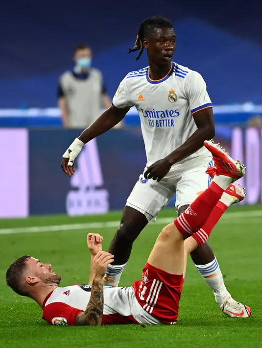 Pemain Celta Vigo Franco Cervi terjatuh di depan pemain Real Madrid Eduardo Camavinga pada pertandingan Liga Spanyol di Stadion Santiago Bernabeu, Madrid, Spanyol, 12 September 2021. Karim Benzema mencetak hattrick saat Real Madrid mengalahkan Celta Vigo 5-2. (GABRIEL BOUYS/AFP)