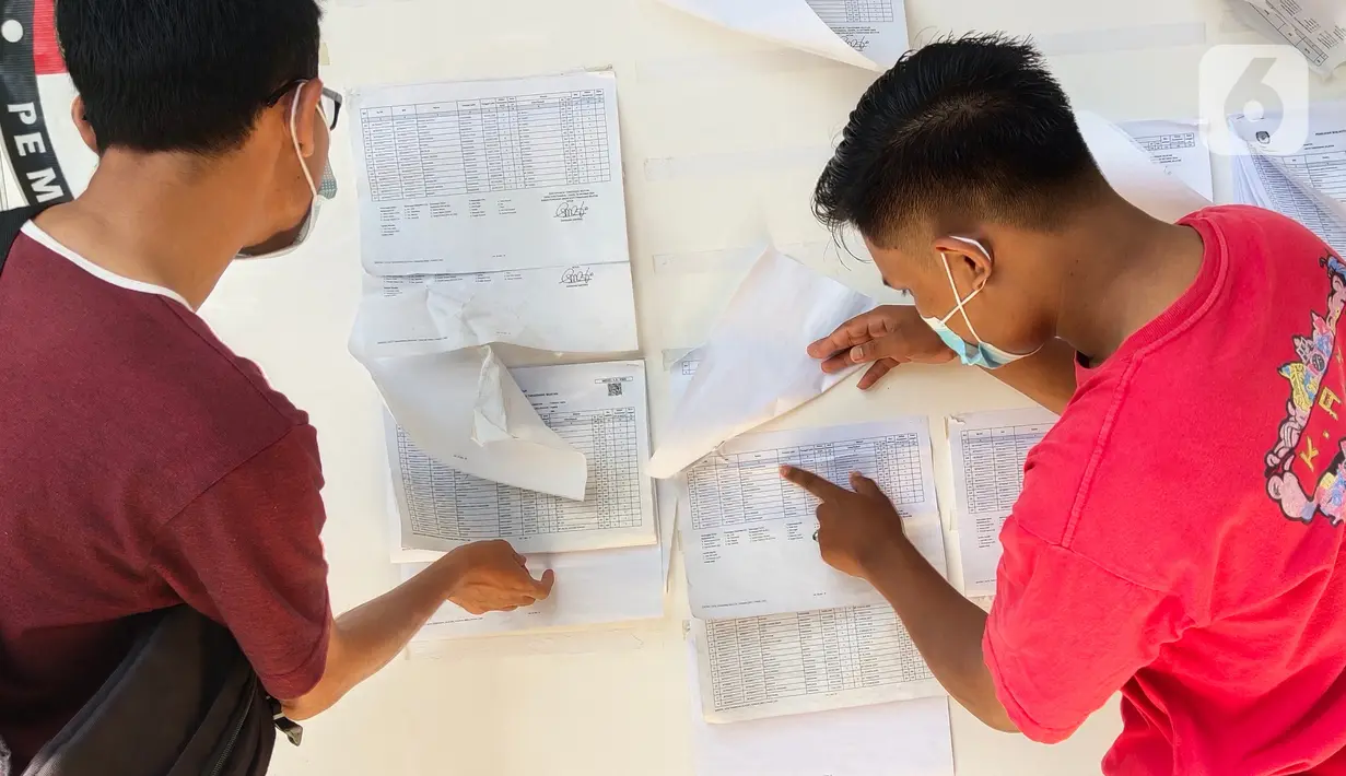 Warga mengecek Daftar Pemilih Tetap (DPT) di kelurahan Parigi, Tangerang, Selasa (8/12/2020). Jelang pilkada serentak khususnya wilayah Tangerang Selatan banyak warga yang melakukan pengecekan untuk memastikan nama mereka terdaftar sebagai DPT di wilayah tersebut. (Liputan6.com/Angga Yuniar)