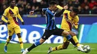 Striker Inter Milan, Lautaro Martinez, berebut bola dengan bek Barcelona, Jean-Clair Todibo, pada laga Liga Champions di Stadion San Siro, Milan, Selasa (10/12). Inter kalah 1-2 dari Barcelona. (AFP/Isabella Bonotto)