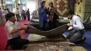 Pedagang memamerkan karpet tenun dagangannya kepada pengunjung pameran di Teheran, Iran, Kamis (29/8/2019). Pemberlakuan sanksi atas Iran oleh AS juga mempengaruhi pasar di Eropa dan negara-negara lain. (AP Photo/Vahid Salemi)