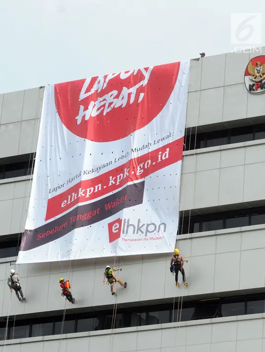 Aktivis membentangkan spanduk raksasa dengan cara repling turun dari gedung C Komisi Pemberantasan Korupsi (KPK) di Jakarta, Senin (26/3). (Merdeka.com/Dwi Narwoko)
