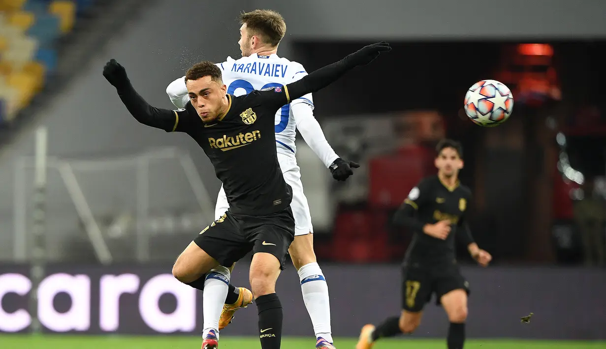 Bek Barcelona, Sergino Dest, berebut bola dengan bek Dynamo Kiev, Oleksandr Karavayev, pada laga Liga Champions di Stadion NSK Olimpiyskiy, Rabu (25/11/2020) dini hari WIB. Barcelona menang 4-0 atas Dynamo Kiev. (AFP/Sergei Supinsky)