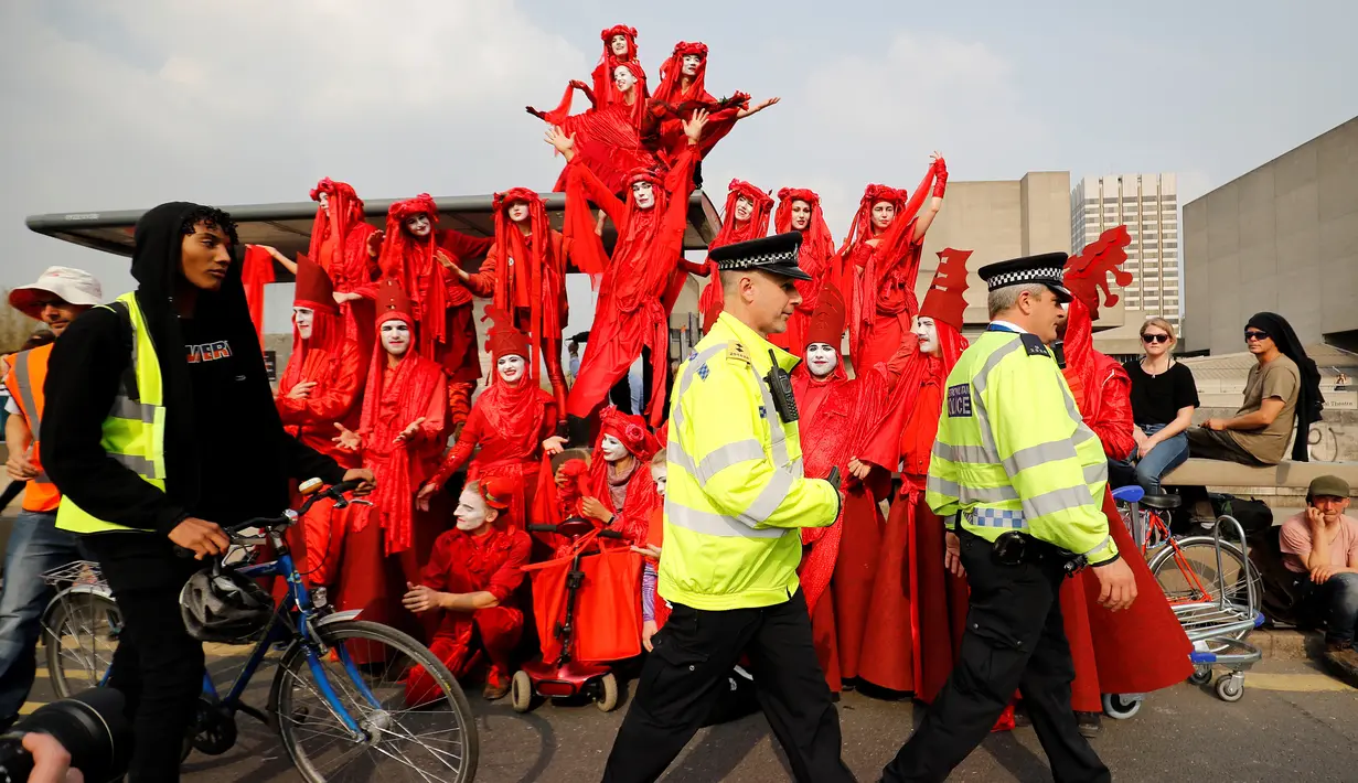 Aktivis lingkungan berdiri di atas halte bus saat melakukan blokade Jembatan Waterloo, London, Inggris (17/4). Aksi blokade ini untuk mendorong pemerintah berbuat lebih dalam mengatasi perubahan iklim yang terjadi. (AFP Photo/Tolga Akmen)