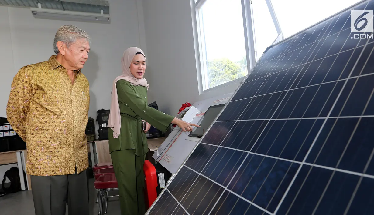 Ketua Pembina Yayasan ORA et LABORA, Edwin Soeryadjaya (kiri) melihat cara kerja Panel Surya Pembangkit Listrik Tenaga Surya di SMK Ora et Labora, BSD Tangerang Selatan, Kamis (18/9). (Liputan6.com/Fery Pradolo)