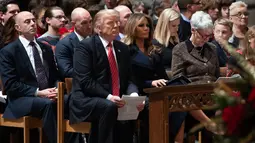 Presiden AS Donald Trump dan Ibu Negara Melania Trump menghadiri Misa Malam Natal di Washington National Cathedral di Washington, DC, (24/12). (AFP Photo/Saul Loeb)