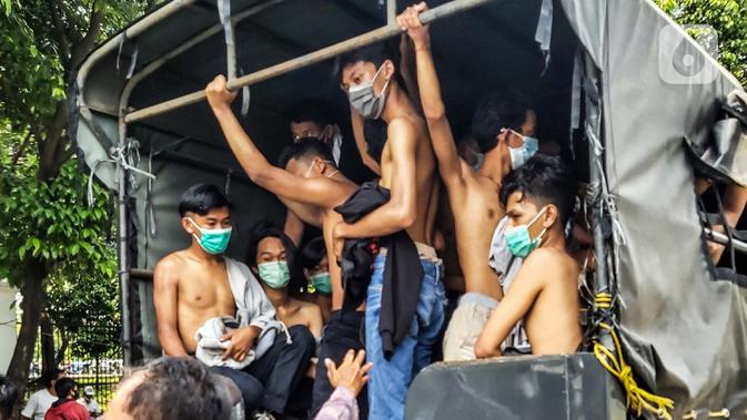 Kendaraan polisi membawa sejumlah remaja yang diamankan saat berkumpul di Kawasan Palmerah, Jakarta, Kamis (8/10/2020). Dari hasil pemeriksaan, mereka turun ke jalan karena mendapatkan undangan dari media sosial untuk melaksanakan aksi unjuk rasa di sekitar DPR. (Liputan6.com/Faizal Fanani)