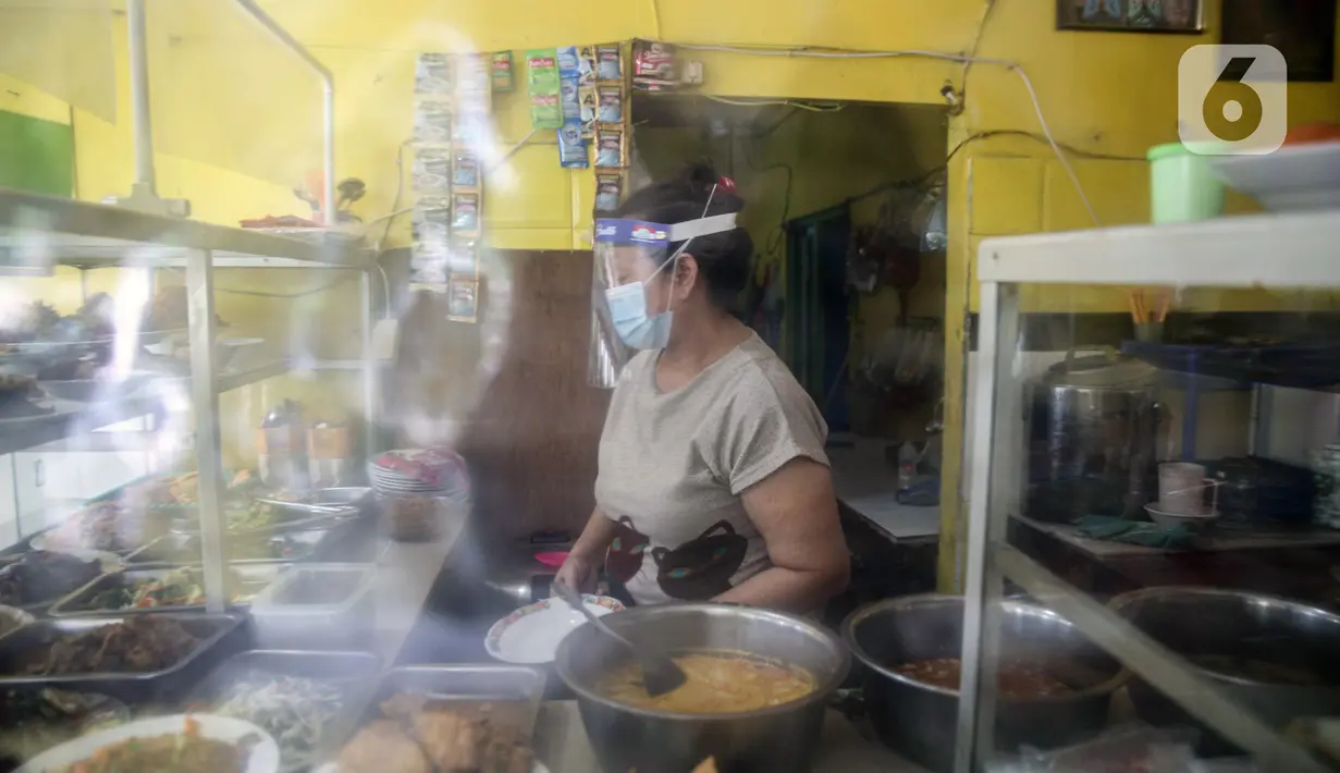 Pelayan mengenakan masker serta sarung tangan dan pelindung wajah saat melayani pelanggan di Warteg Ellya, Cilandak Timur, Pasar Minggu, Jakarta, Selasa (21/7/2020). Warteg Ellya menerapkan protokol kesehatan pencegahan penyebaran COVID-19 sejak penerapan PSBB transisi. (Liputan6.com/Faizal Fanani)