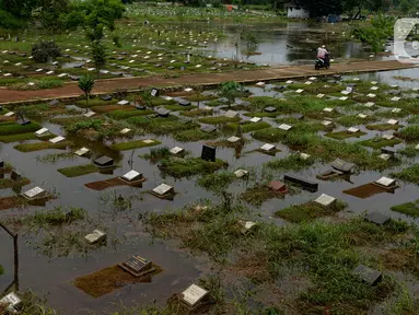 Banjir merendam sejumlah makam di Tempat Pemakaman Umum (TPU) Tanah Kusir, Jakarta, Jumat (3/1/2020). TPU Tanah Kusir terendam banjir setelah Kali Pesanggrahan meluap akibat intensitas hujan  yang tinggi pada Rabu lalu. (merdeka.com/Imam Buhori)