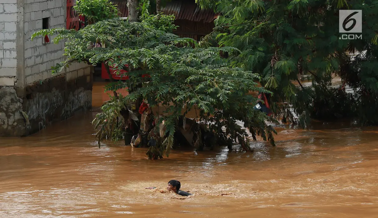 Seorang anak berenang di Sungai Ciliwung yang meluap di kawasan Rawajati, Jakarta, Jumat (26/4). Tingginya volume debit air yang berasal dari Bogor tidak menyurutkan niat anak-anak itu untuk tetap berenang, meskipun berbahaya bagi keselamatan. (Liputan6.com/Immanuel Antonius)
