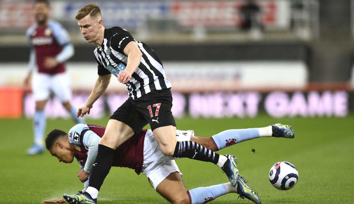 Gelandang Aston Villa, Jacob Ramsey (bawah) terjatuh saat perebutan bola dengan bek Newcastle United, Emil Krafth dalam laga lanjutan Liga Inggris 2020/2021 pekan ke-28 di St. James' Park, Jumat (12/3/2021). Aston Villa bermain imbang 1-1 dengan Newcastle United. (AP/Stu Forster/Pool)
