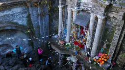 Wisatawan mengamati bangunan gereja San Juan Parangaricutiru di Angahuan, Meksiko, 17 Januari 2016. Gereja ini disebut sebagai keajaiban Tuhan karena luput dari sapuan lava gunung berapi pada  20 februari 1943 silam. (AFP PHOTO / Mario Vazquez)
