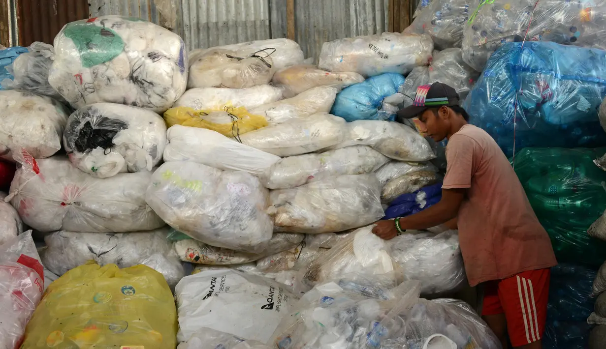 Pengumpul sampah memilih botol plastik di sebuah gudang sampah di Nusa Dua, di pulau resor Indonesia Bali (2/5). (AFP Photo/Sonny Tumbelaka)