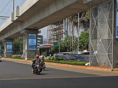 Pengendara melintasi videotron penghormatan kepada tenaga medis yang gugur akibat Covid-19 di tiang penyangga lintasan MRT, Jalan Sisingamangaraja, Jakarta, Jumat (18/9/2020). Keberadaan videotron tersebut diharap mampu membuat masyarakat waspada akan ancaman Covid-19. (Liputan6.com/Herman Zakharia)