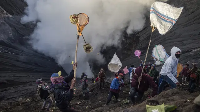 FOTO: Upacara Yadnya Kasada, Suku Tengger Larung Sesajen ke Kawah Gunung Bromo