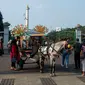 Pengunjung naik delman melintas di depan Monas ketika hari libur Lebaran hari kedua, Jakarta, Kamis (6/6/2019). Libur hari Lebaran dimanfaatkan sejumlah warga dari Jabodetabek untuk berpergian ke tempat wisata yang ada di Jakarta. (merdeka.com/Imam Buhori)