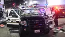 Petugas memeriksa kendaraan polisi yang dirusak pengunjuk rasa di Oakland, California, Rabu (9/11). Sebagian warga AS turun ke jalan-jalan di seluruh wilayah Amerika Serikat tak terima dengan kemenangan Donald Trump dalam Pilpres AS. (REUTERS/Noah Berger)