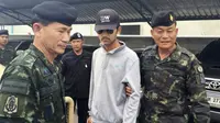 Petugas Royal Thai Army bersama seorang tersangka yang diduga terlibat pengeboman Kuil Erawan, Bangkok, yang ditangkap di sebuah pos pemeriksaan di perbatasan Kamboja, Selasa (1/9/2015). (REUTERS/National Council for Peace and Order)