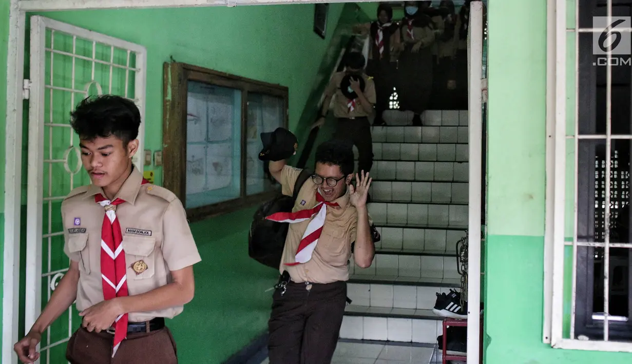 Sejumlah siswa berlarian menyelamatkan diri saat simulasi bencana di SMA Negeri 78 Jakarta, Rabu (23/1). Kegiatan itu untuk pengenalan kepada siswa-siswi dengan program siaga bencana berupa simulasi evakuasi gempa dan tsunami. (Liputan6.com/Faizal Fanani)