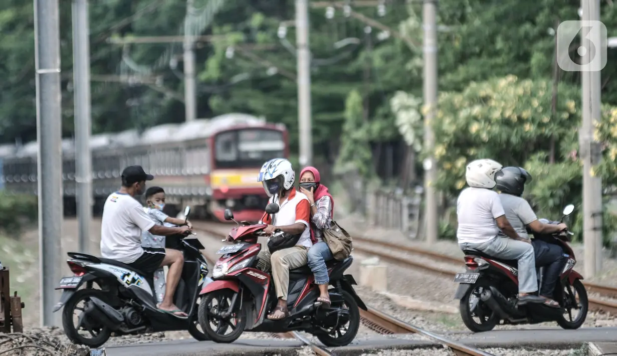 Pengendara motor saar melintasi perlintasan sebidang tanpa palang pintu di kawasan TPU Tanah Kusir, Jakarta, Kamis (17/9/2020). Sebelumnya pada Kamis (17/9) pagi tadi terjadi kecelakaan yang melibatkan sebuah mobil dan KRL di perlintasan tersebut. (merdeka.com/Iqbal S. Nugroho)