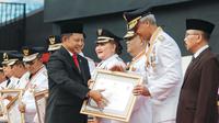 Gubernur Jawa Tengah, Ganjar Pranowo saat menerima penghargaan yang diberikan Menteri Dalam Negeri, Tito Karnavian pada Peringatan Hari Otonomi Daerah (Otda) XXVII.