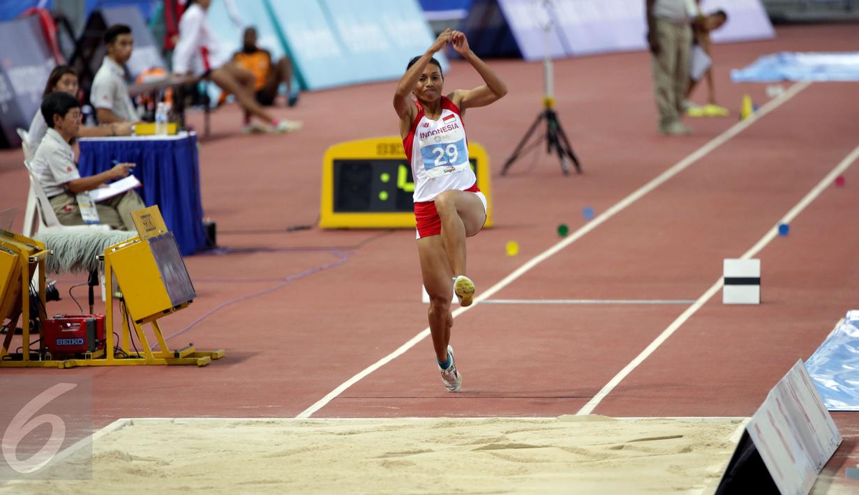 Atlet putri Indonesia, Maria Londa saat melakukan lompatan di nomor lompat jangkit di National Stadium, Singapura, Kamis (11/6/2015). Maria mencatat lompatan sejauh 13,75 meter dan berhasil meraih medali emas. (Liputan6.com/Helmi Fithriansyah)