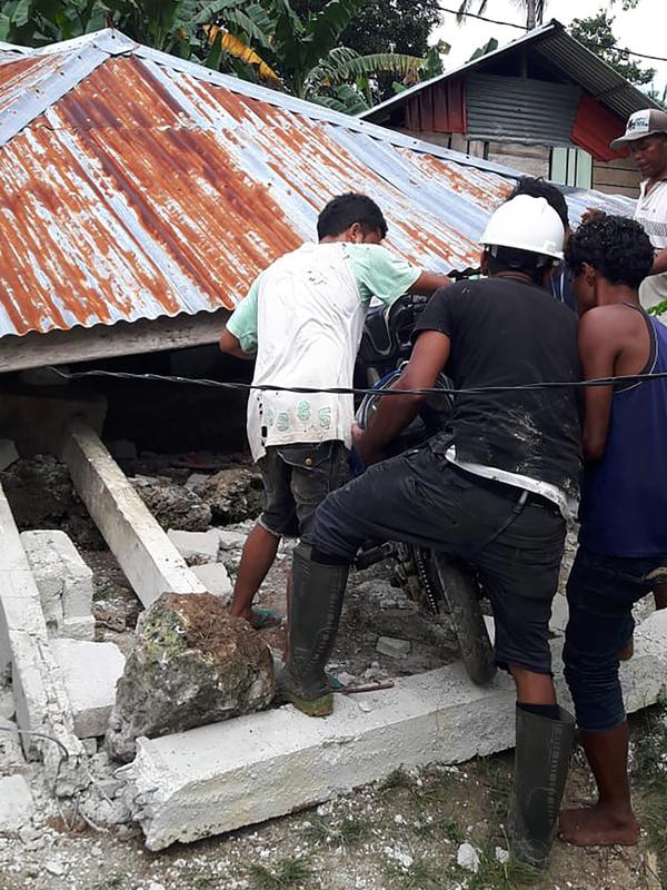 Sejumlah orang mengeluarkan motor dari rumah yang rusak akibat gempa di Ambon, Maluku, Jumat (27/9/2019). Badan Nasional Penanggulangan Bencana (BNPB) mengatakan 171 rumah rusak akibat gempa Magnitudo 6,5 yang mengguncang Maluku pada 26 September 2019. (HO/BADAN NASIONAL PENANGGULANGAN BENCANA/AFP)