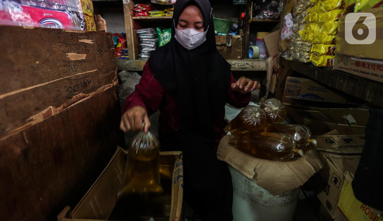 Pedagang menata minyak goreng curah di kiosnya Pasar Kebayoran Lama, Jakarta, Rabu (19/1/2022). Pemerintah resmi mengimplementasikan kebijakan minyak goreng satu harga Rp14.000 per liter untuk semua jenis kemasan mulai hari ini. (Liputan6.com/Johan Tallo)