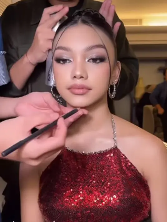 Untuk kesan jenjang di leher, rambut panjang Naura Ayu ditata dengan updo tinggi dan sehelai poni [@itsfrankywu]