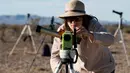Seorang wanita menggunakan alat khusus bersiap untuk melihat gerhana matahari annular di Estancia El Muster, Argentina (26/2). Para astronom dan penyuka astronomi di Argentina berkumpul untuk menyaksikan gerhana matahari annular. (AFP/Alejandro Pagni)