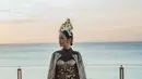 Jumpsuite batik bermotif kembang dan dedaunan ini terlihat kompleks berkat aksen pita cokelat mengilap pada pinggang dan “sayap” yang menempel di punggung Lyodra Ginting. Penampilannya makin paripurna berkat tiara yang bertakhta di atas kepala. Tak perlu status panjang lebar untuk menjelaskan busana rilisan Griya Ageman Jogja ini. Sang penyanyi menyematkan emotikon Sang Merah Putih sebagai status teks. (Foto: Dok. Instagram @lyodraofficial)