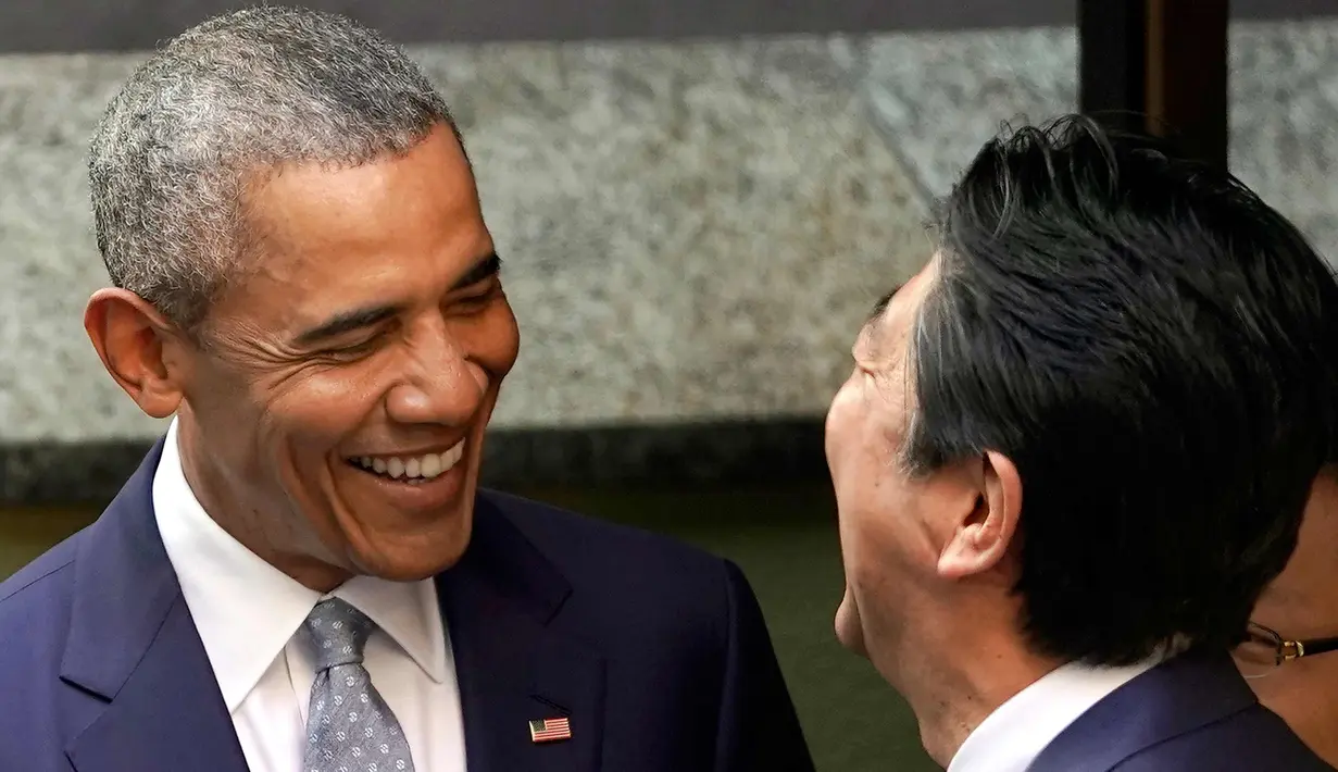 Presiden AS ke-44 Barack Obama dan PM Jepang, Shinzo Abe tertawa di depan salah satu restoran sushi di kawasan Ginza, Tokyo, Jepang, (25/3). (AP Photo / Shizuo Kambayashi, Pool)