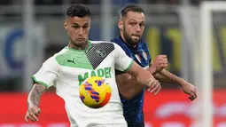 Penyerang Sassuolo, Gianluca Scamacca berebut bola dengan bek Inter Milan, Stefan de Vrij selama pertandingan lanjutan Liga Serie A Italia di Stadion San Siro, di Milan, Italia, Senin (21/2/2022). Inter Milan kalah atas Sassuolo 0-2. (AP Photo/Antonio Calanni)
