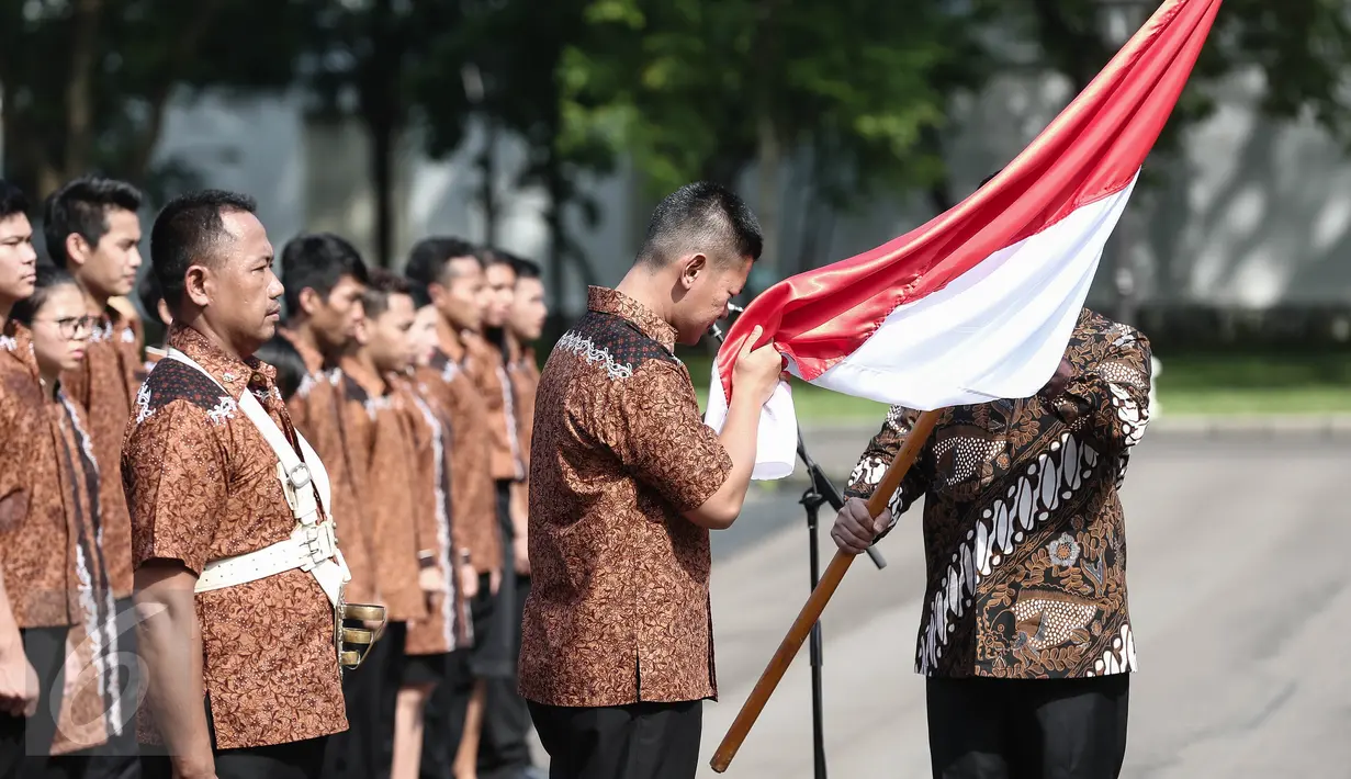 Seorang kontingen Olimpiade mencium bendera dalam pelepasan Tim Indonesia menuju Olimpiade 2016 di Brasil, di halaman Istana Merdeka, Jakarta, Rabu (22/6). Sebanyak 26 atlet akan bertarung pada pesta olah raga tingkat dunia. (Liputan6.com/Faizal Fanani)