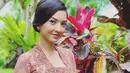 Lagi, Raline Shah tampil menawan dalam balutan kebaya Bali. Kebaya Bali sederhana bernuansa merah muda-ungu ini dipadu dengan kain Bali dengan sentuhan warna emas yang serasi. Bros emas disematkan di selendang abu-abu yang diikatkan di pinggangnya. [Foto: Instagram/ralineshah]