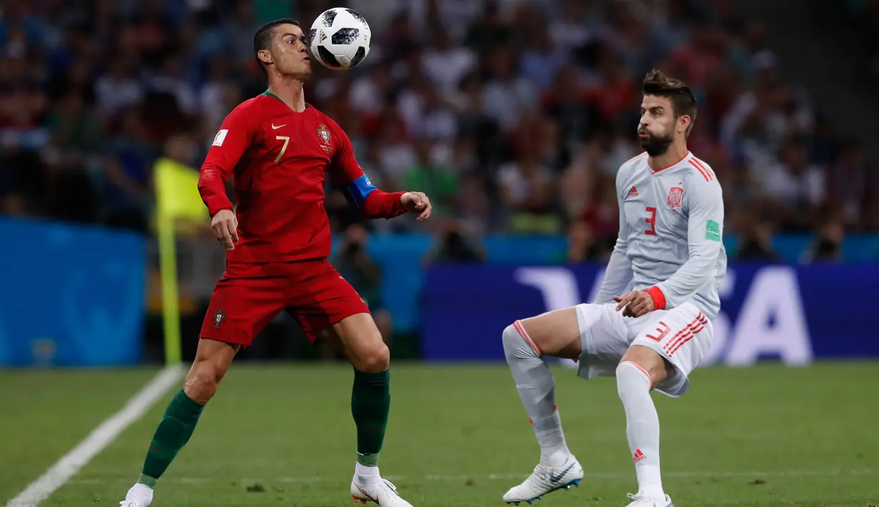 Penyerang Portugal Cristiano Ronaldo berusaha mengontrol bola dari kawalan bek Spanyol Gerard Pique saat bertanding pada grup B Piala Dunia 2018 di Stadion Fisht di Sochi, Rusia (15/6). Portugal dan Spanyol bermain imbang 3-3. (AP Photo/Manu Fernandez)