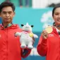 Petenis ganda campuran Indonesia Christopher Rungkat (kiri) dan Aldila Sutjiadi menggigit medali emas pada upacara penganugerahan medali seusai menang atas petenis Thailand Luksika Kumkhum dan Sonchat Ratiwatana pada final tenis ganda campuran Asian Games