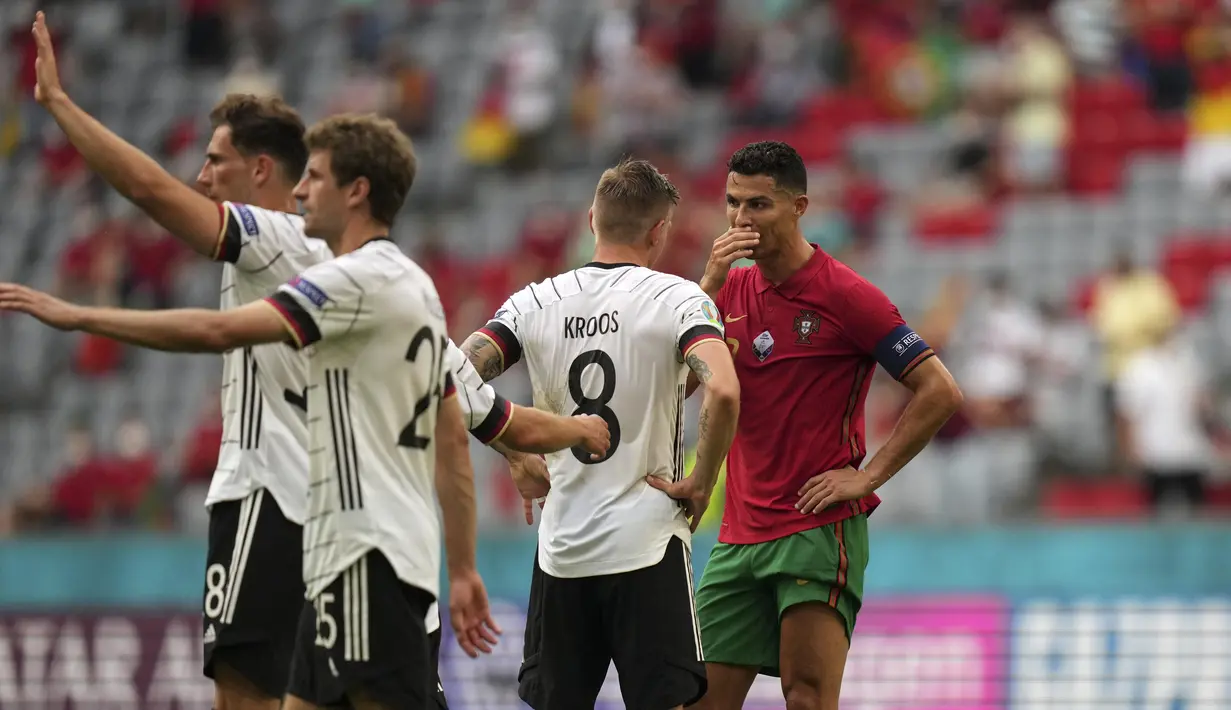 Penyerang Portugal, Cristiano Ronaldo berbicara dengan gelandang Jerman, Toni Kroos usai pertandigan grup F Euro 2020 di Allianz Arena, Munich, Sabtu (19/6/2021). Portugal takluk dari Jerman dengan skor 2-4. (AP Photo/Matthias Schrader, Pool)