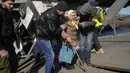 Relawan melewati jalan setapak di bawah jembatan yang hancur saat mereka mengevakuasi seorang warga lanjut usia di Irpin, barat laut Kiev, pada Jumat (11/3/2022). Invasi Rusia ke Ukraina sudah memasuki hari ke-16 pada hari Jumat ini. (AP Photo/Efrem Lukatsky)