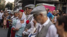 Orang-orang yang mengenakan pakaian tradisional 'chulapo' menari selama perayaan San Cayetano, santo pelindung tenaga kerja dan roti, di lingkungan Lavapies di Madrid, Spanyol, Sabtu (6/8/2022). Festival San Cayetano menandai awal dari serangkaian festival populer di Madrid. (AP Photo/Manu Fernandez)