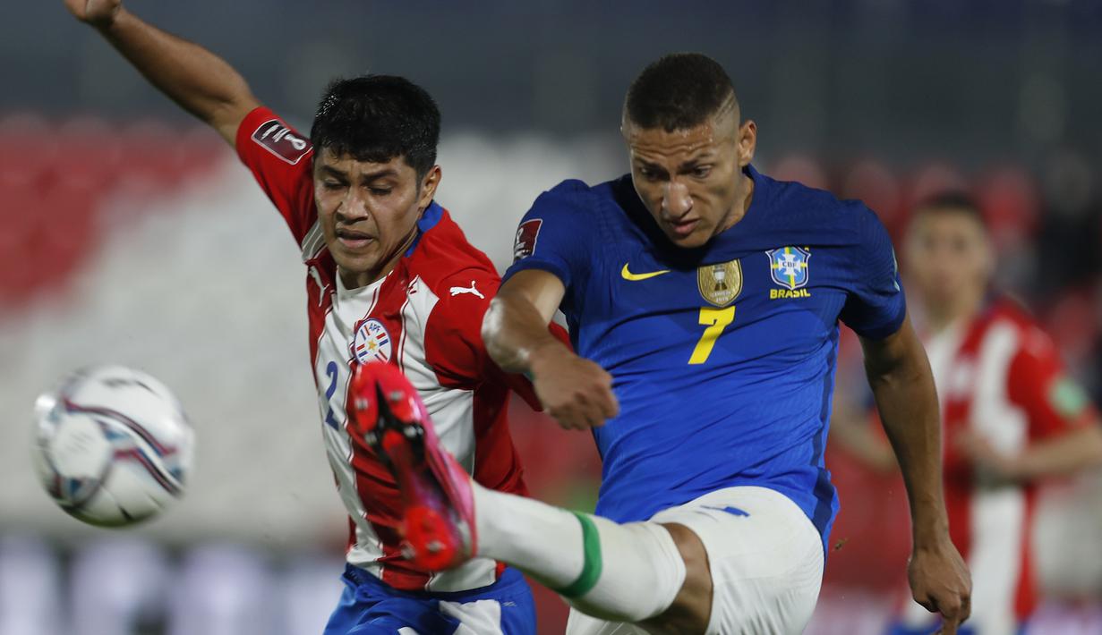 Striker Brasil, Richarlison (kanan) melepaskan tendangan dibayangi bek Paraguay, Roberto Rojas dalam laga kualifikasi Piala Dunia 2022 Zona Conmebol di Defensores del Chaco Stadium, Asuncion, Selasa (8/6/2021). Brasil menang 2-0 atas Paraguay. (AP/Jorge Saenz)
