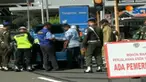 Petugas gabungan bersenjata lengkap memeriksa kendaraan roda empat yang dicurigai secara acak.
