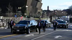 Iring-iringan mobil Presiden AS Joe Biden dan Wakil Presiden AS Kamala Harris menuju Gedung Putih melewati Museum Nasional Sejarah dan Budaya Afrika Amerika (kiri) di Washington, DC, Rabu (20/1/2020). (JIM WATSON / AFP)