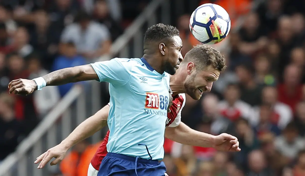 Bek Arsenal, Shkodran Mustafi, duel udara dengan striker Bournemouth, Jermain Defoe, pada laga Premier League di Stadion Emirates, London, Sabtu (9/9/2017). Arsenal menang 3-0 atas Bournemouth. (AFP/Ian Kington)