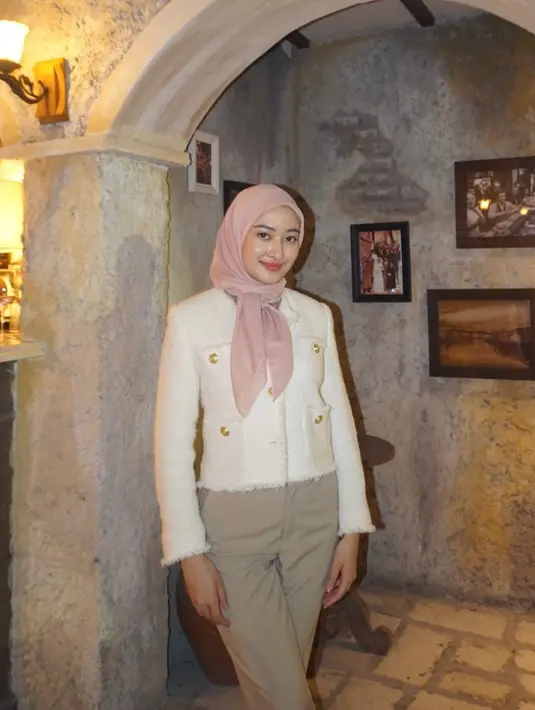 Hijab segi empat yang dililit ke belakang hingga ke depan satu ini membuat tampilan Puteri menjadi manis. [@putmod].