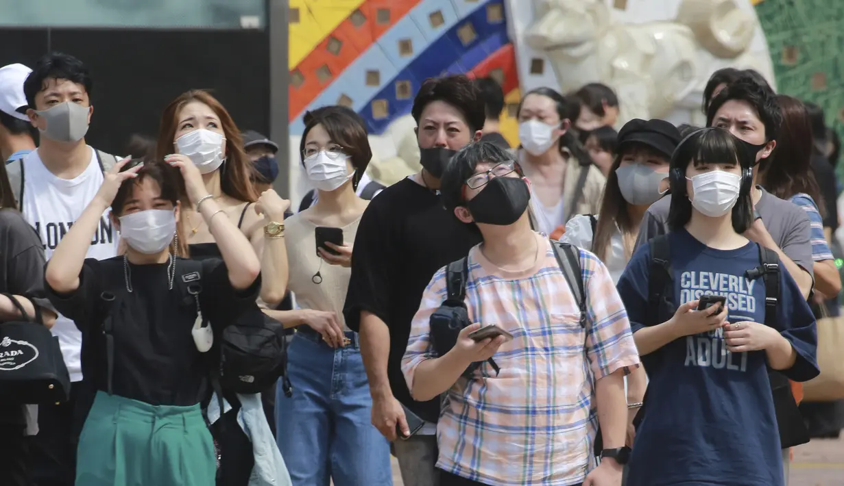 Orang-orang yang memakai masker untuk membantu melindungi diri dari penyebaran virus corona berdiri di persimpangan di Tokyo, Senin (30/8/2021). Kementerian Kesehatan Jepang tengah menginvestigasi kematian dua orang yang menerima vaksin COVID-19 Moderna pada Agustus lalu. (AP Photo/Koji Sasahara)