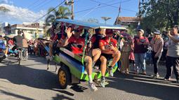 Pembalap tim Team HRC naik andong di Kota Sumbawa, NTB, Jumat (23/6/2023) menjelang balapan MXGP Sumbawa 2023 di Sirkuit Samota pada 24-25 Juni 2023. Tim HRC menurunkan dua crosser, Ruben Fernandes dan Tim Gajser. (Bola.com/Wiwig Prayugi)